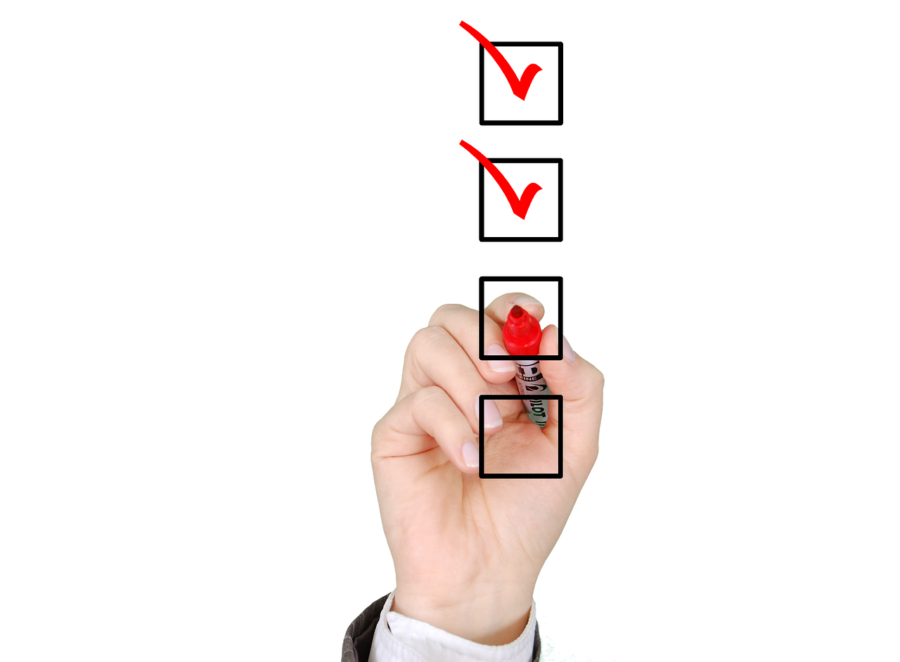 Person checking off "to do" boxes with red marker.